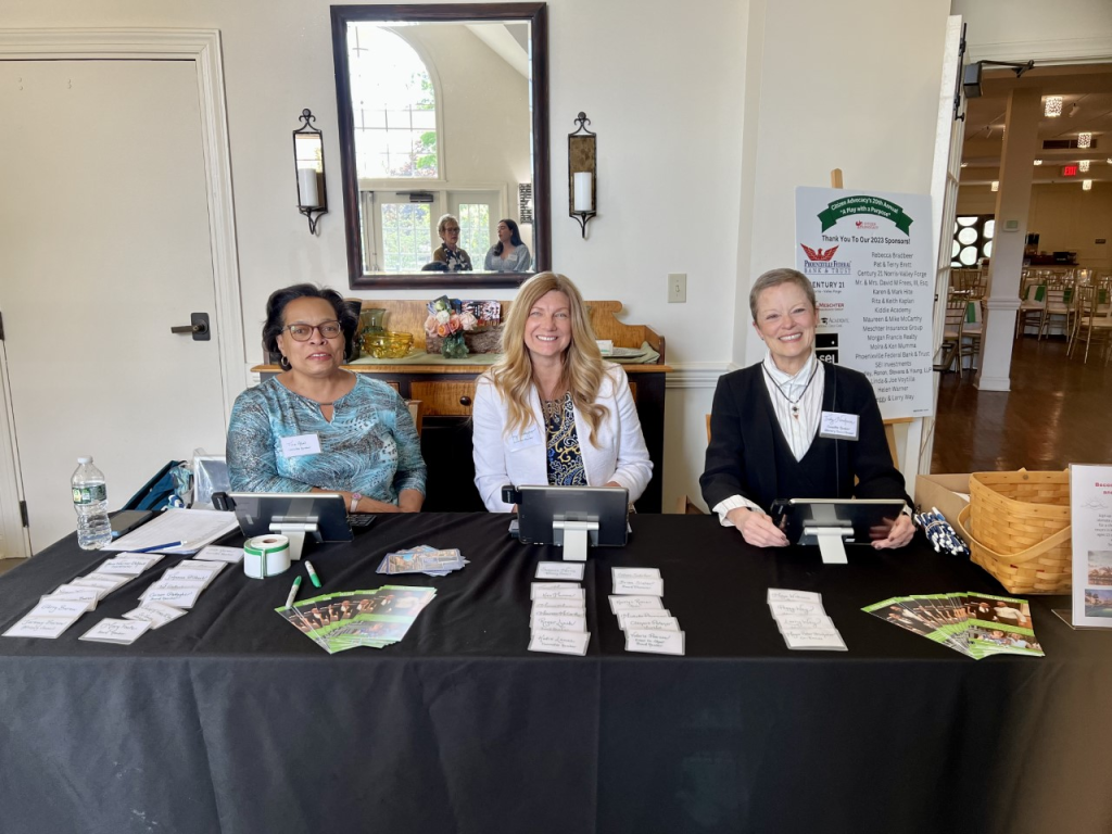 Theater Event volunteers sit at a table ready to greet attendees 